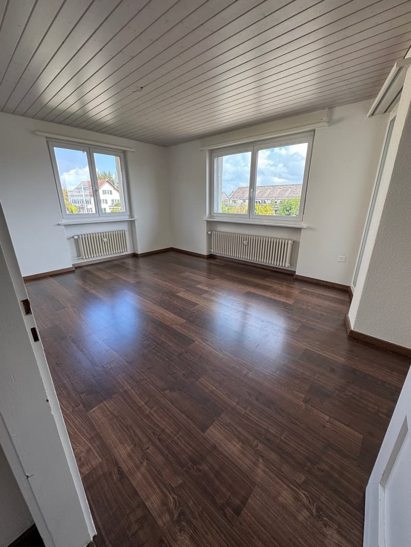 empty room, wooden floor, white walls, two windows, radiators