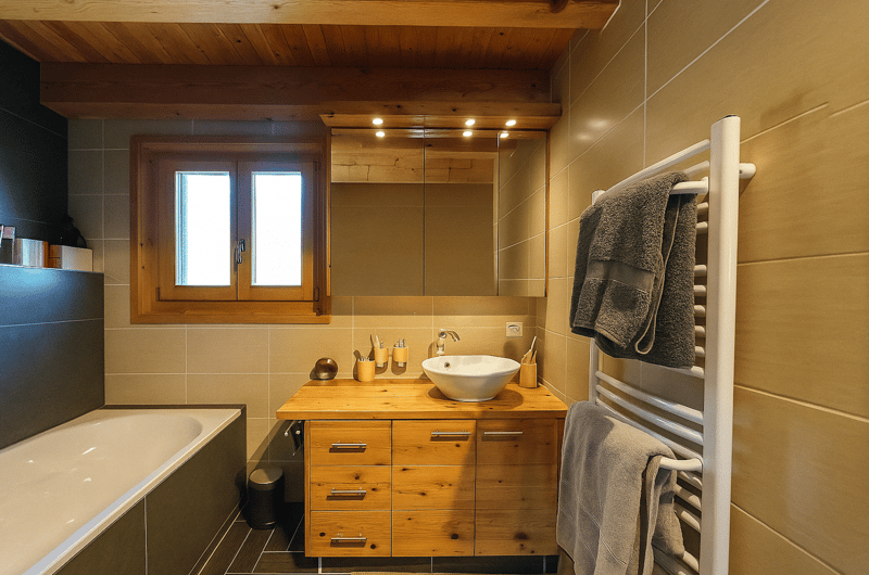 Bathroom with bathtub, sink, mirror, radiator, towels, toiletries, window, wooden walls and floor