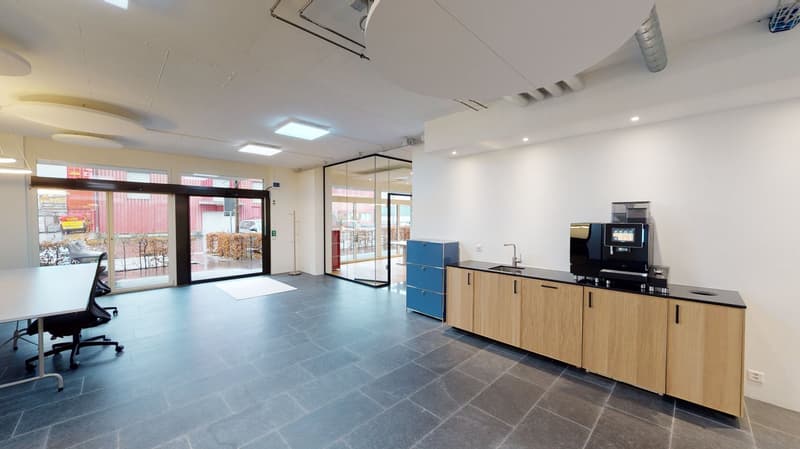 modern office space, gray tile flooring, glass doors, blue drawers, white wall, wooden cabinets, countertop with sink, office chair, desk, office equipment