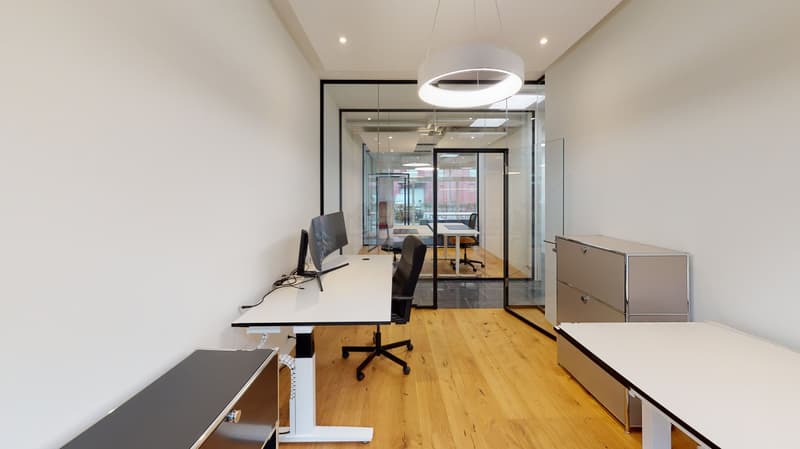 Office: white walls, wooden floors, glass walls, adjustable height desk, chair, computer