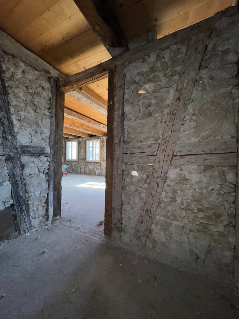 exposed stone walls, wooden beams, entrance, large windows