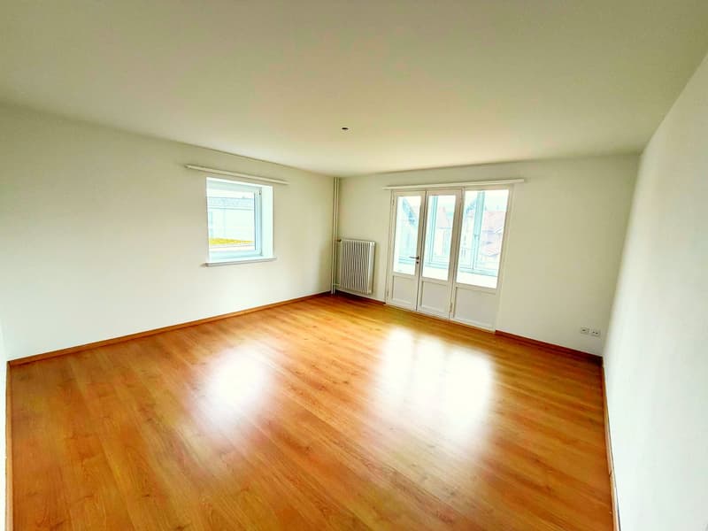 empty room, wooden floor, white walls, two windows, sliding glass doors, radiator