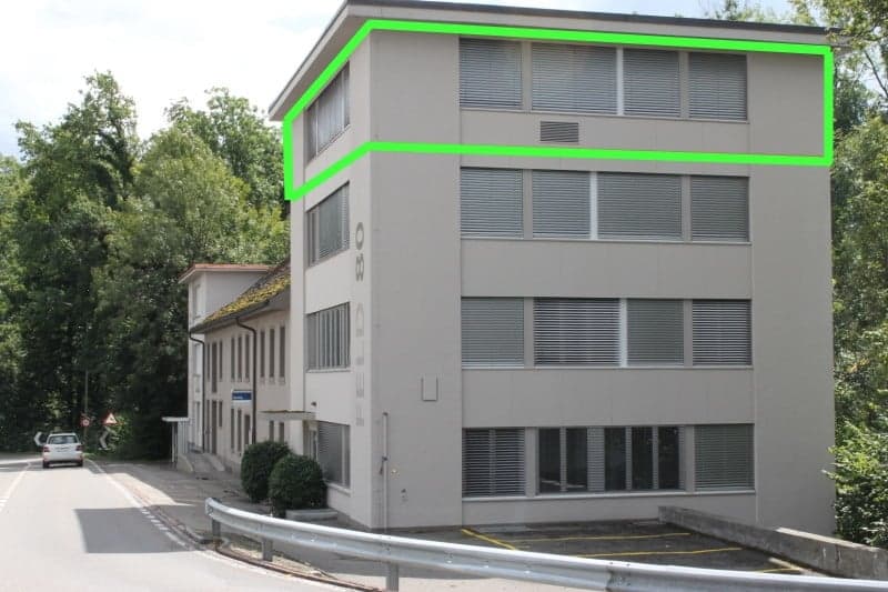 2 story building, large windows, driveway, green outline