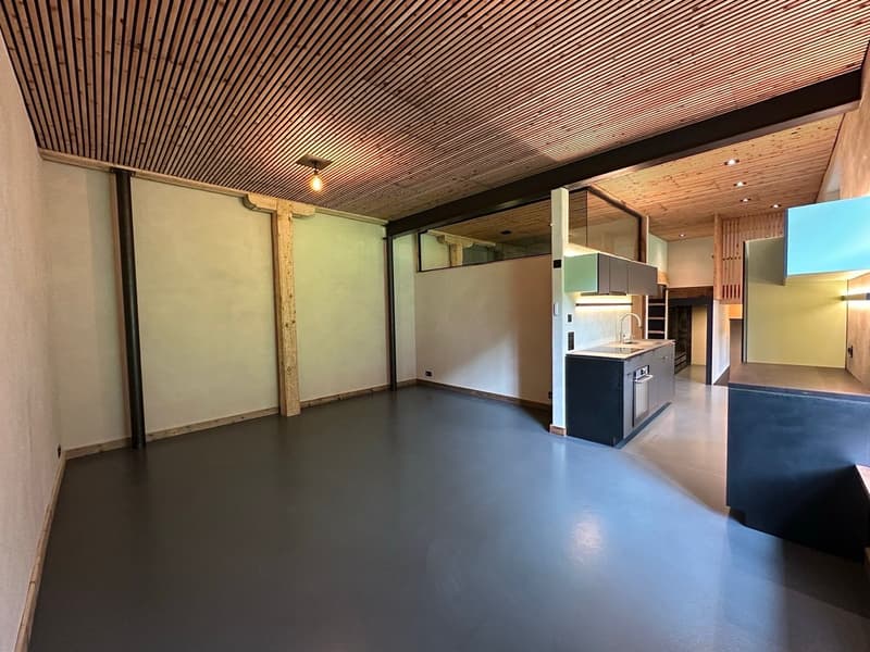 Empty kitchen with gray floor, white walls, wooden ceiling, sink, cabinets