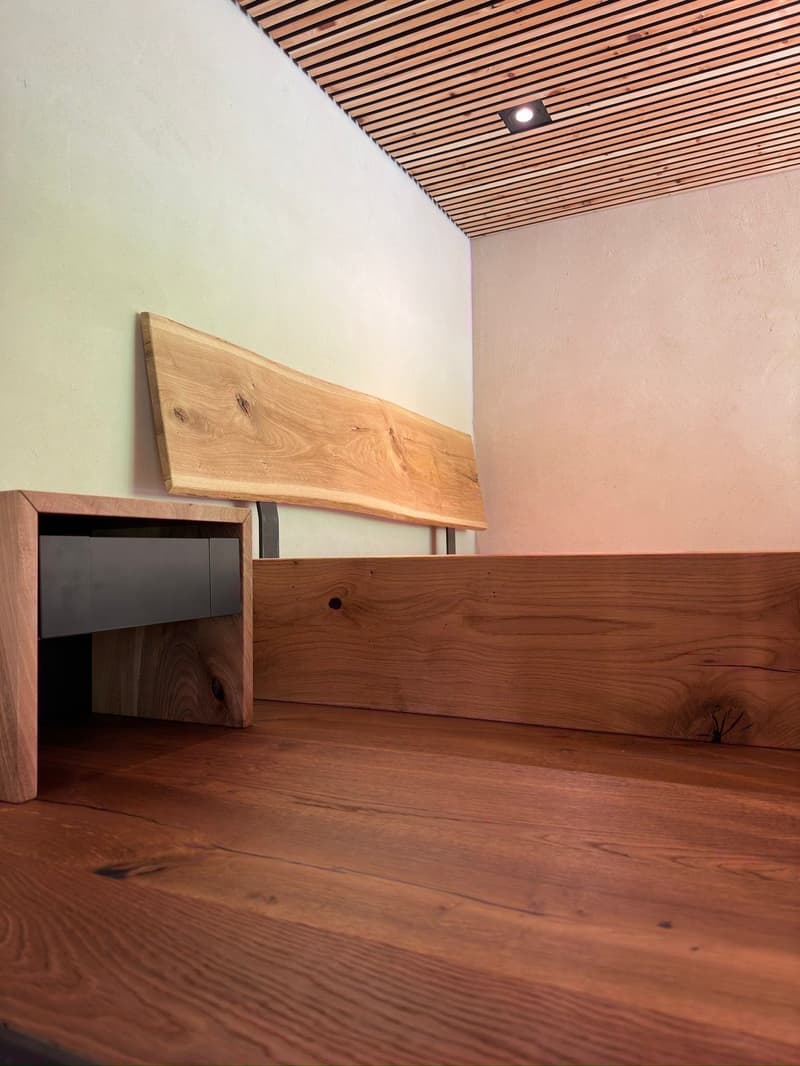 Wooden furniture, wooden floor, white wall, wood paneling on ceiling