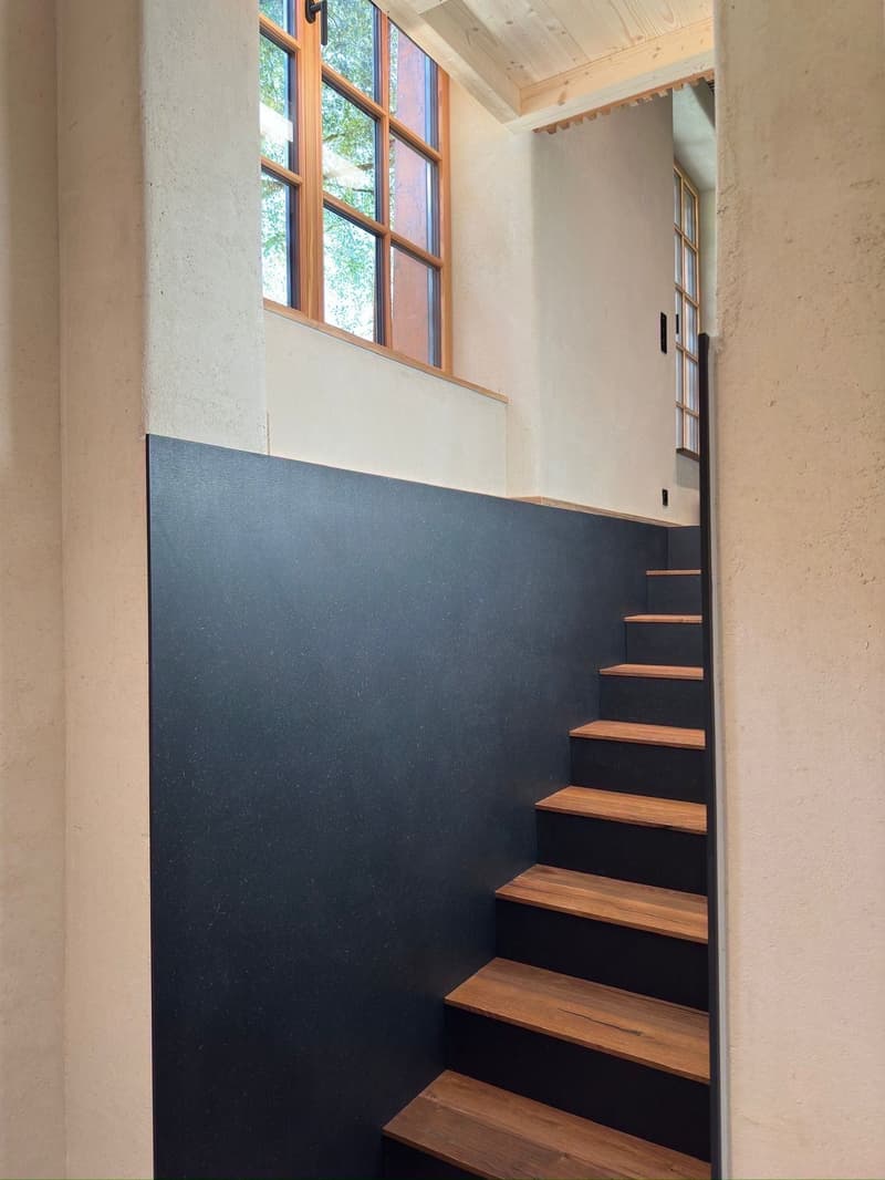 wooden stairs, black wall, wooden ceiling, window
