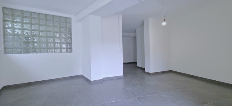 empty room, white walls, gray tiles, glass block window, ceiling light
