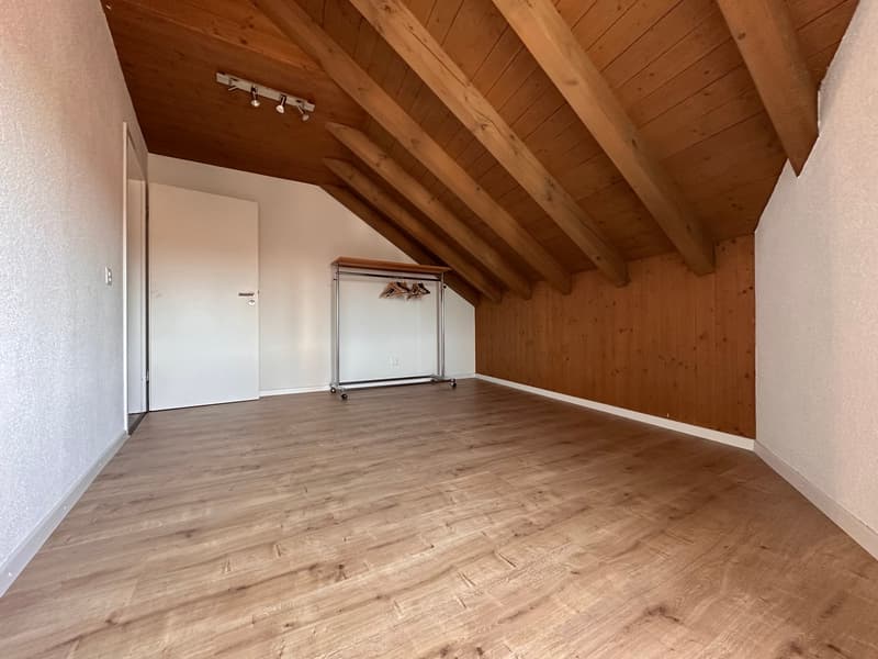 empty attic room with wooden walls, wooden beams ceiling, wooden floor