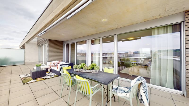 Outdoor dining area with table and chairs, couch, plants, rug, sliding glass doors, view of the city