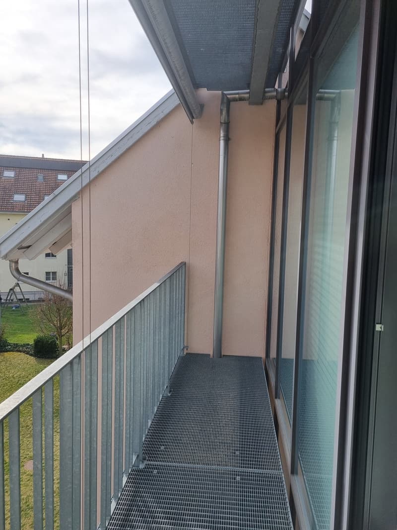 Balcony with metal railing, metal floor, glass doors, metal pipe