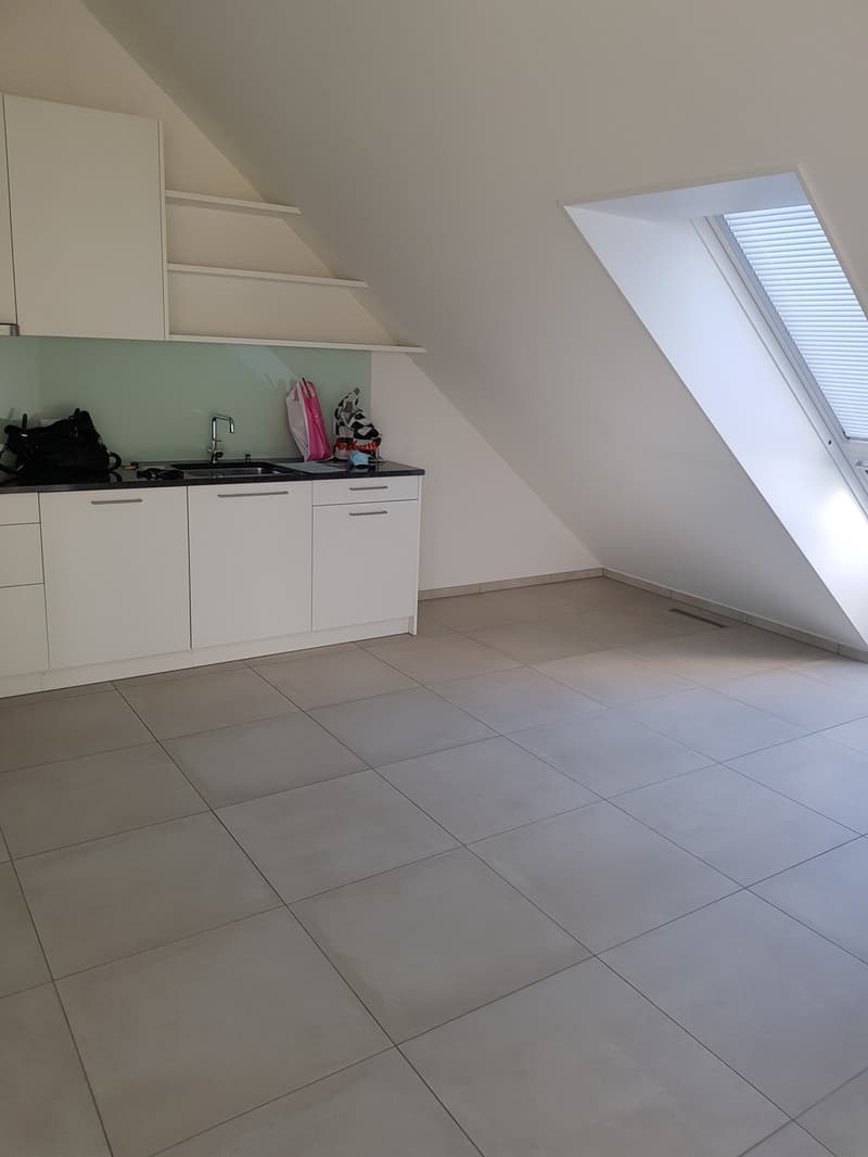 kitchen with white cabinets, tiled floor, sink, faucet, skylight