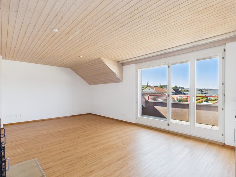 empty room, wooden floor, white walls, large glass doors leading to balcony, view of houses and trees