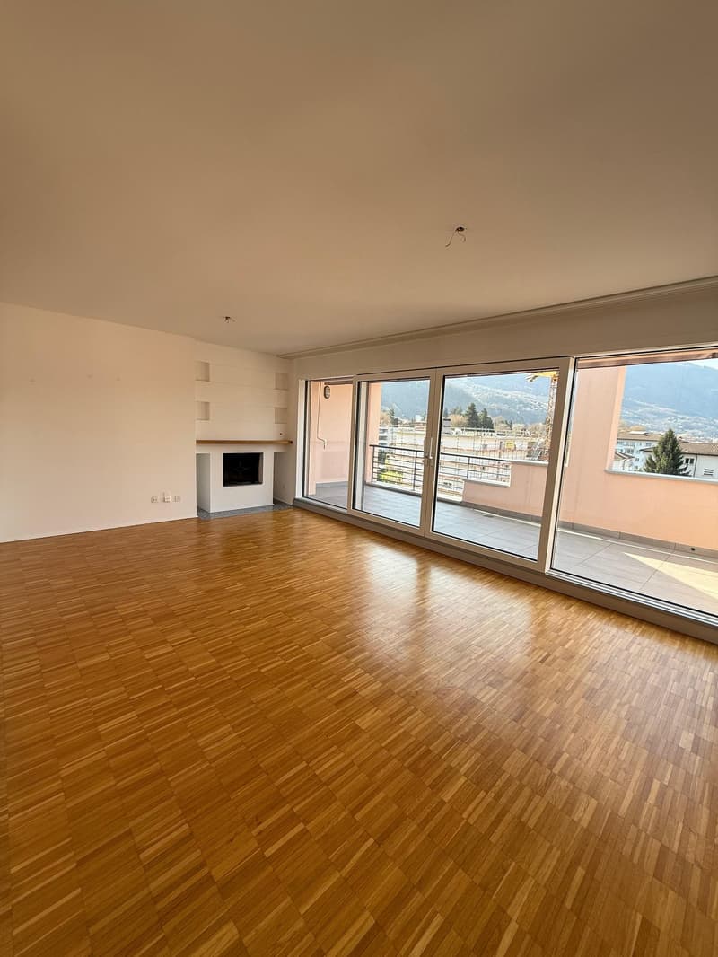 large open space, wooden floor, sliding glass doors, fireplace, balcony
