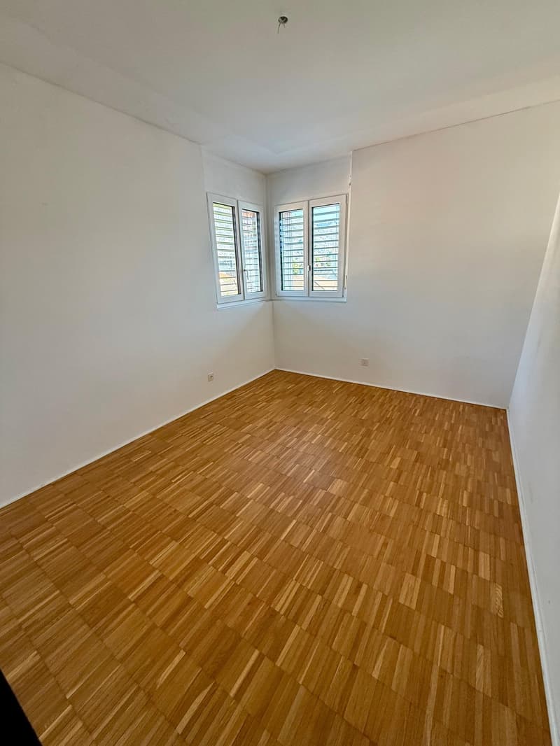 empty room, wooden floor, white walls, two windows, power outlets