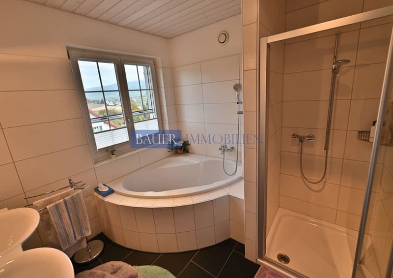 White tiled walls, white toilet, white sink, bathtub with shower head, towel rack