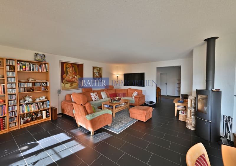 Fireplace, modern couch, wooden floor, bookshelf, wooden coffee table, armchair, ottoman, rug