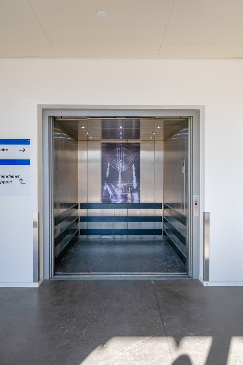 empty elevator shaft, metal interior, glass door, white walls