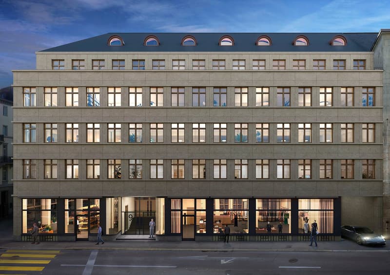 Modern building with multiple floors, large windows, arched windows on the top floor, and a car parked in front.