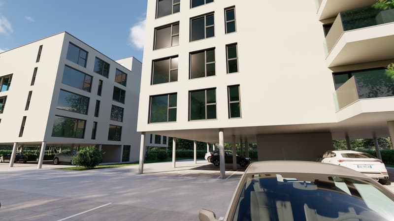 Modern multi-story apartment building with large windows, balconies, and a parking area in front of the building.