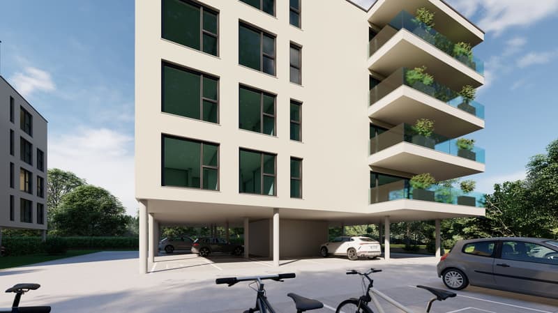 Multi-story apartment building with balconies, parking spaces, and greenery surrounding the building.