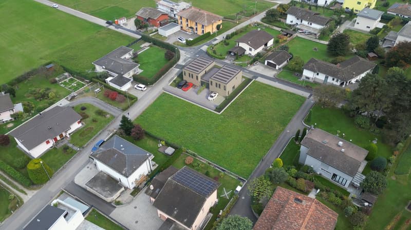 Cluster of houses, with solar panels on rooftops, private driveways, parked cars