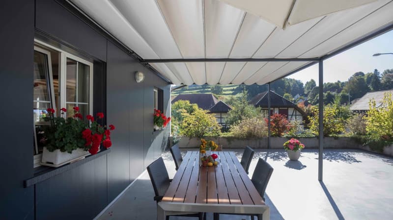 covered terrace, wooden table, chairs, flowers, plants, view of the landscape