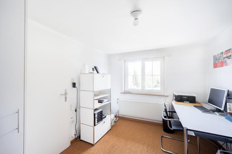 empty room, white walls, white door, white desk, white shelf, radiator, window, computer, keyboard, mouse, monitor