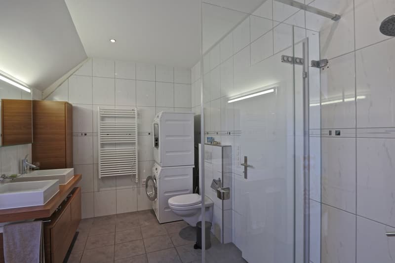 Badezimmer mit eigenem Waschturm und bodentiefer Dusche.