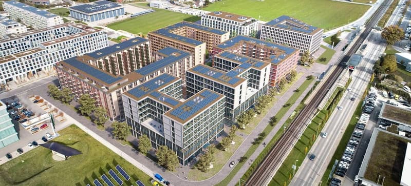 Aerial view of a modern urban development with multiple high-rise office and residential buildings. The buildings have solar panels installed on the roofs, indicating the use of renewable energy. There are also parking lots visible around the buildings.