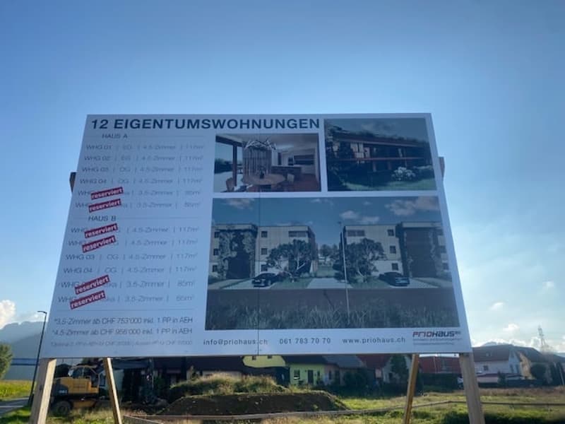 12 Eigentumswohnungen advertisement board showing apartment floor plans and details