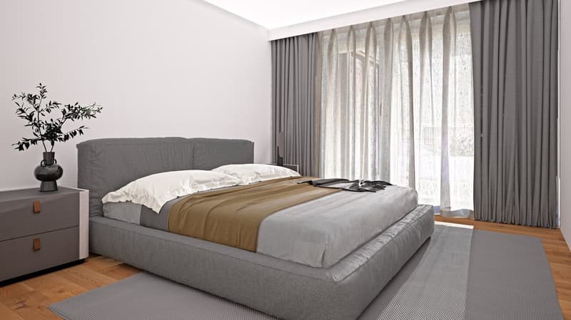 Spacious bedroom with a large gray upholstered bed frame, white bedding, and a beige throw blanket. The room has large windows with sheer curtains, providing natural light. There is a small plant decoration and a gray dresser on the side.