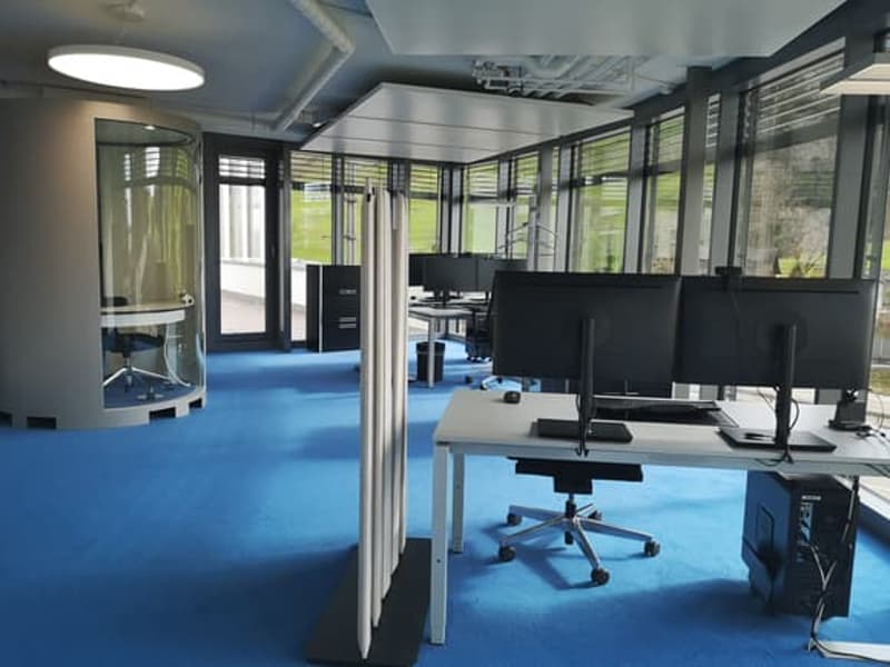 modern office, blue carpet, desks, monitors, computers, chair