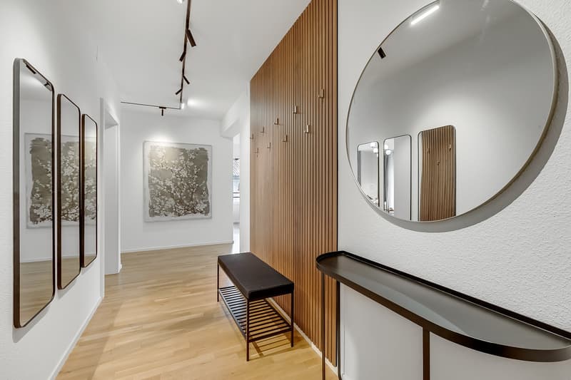 wooden floor, white walls, large mirror, wooden bench, wooden wall paneling, artwork