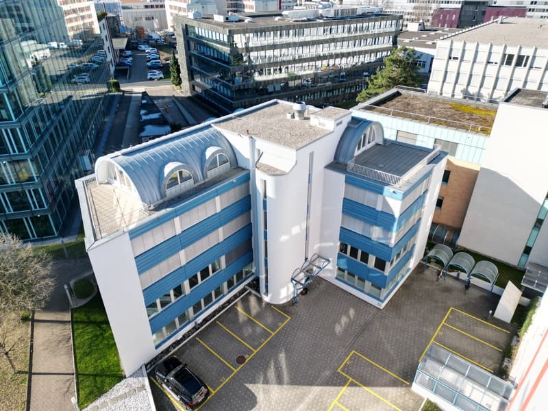 Office building, modern design, glass facade, blue and white exterior, parking area