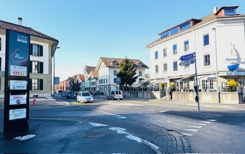 Corner of a street with buildings, cars, and a traffic sign