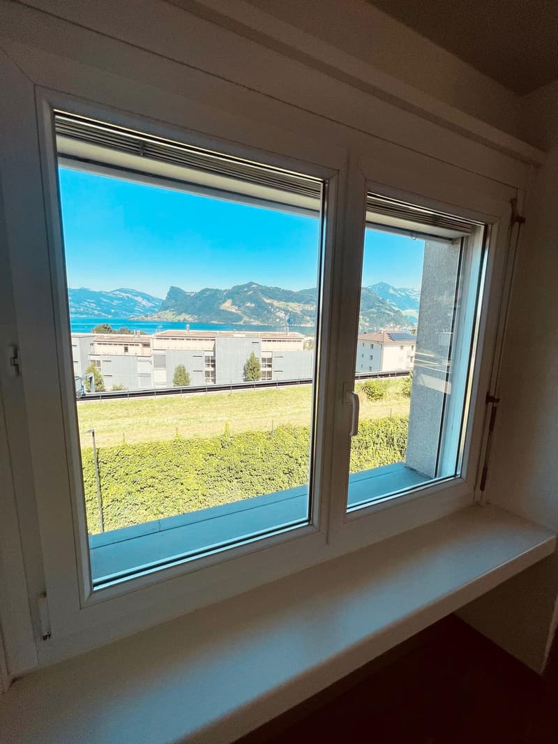 large window with view of mountains and lake