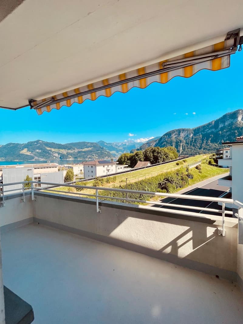 Balcony with railings, awning, view of mountains and lake