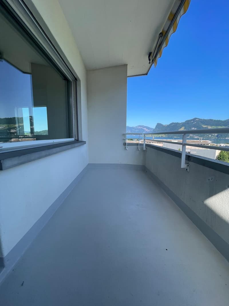 empty balcony with railings, large windows, view of mountains and water