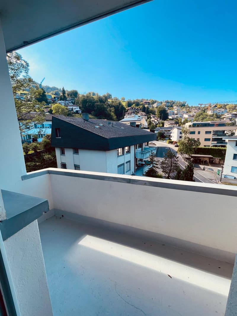 Balcony with white floor, gray railing, view of the town
