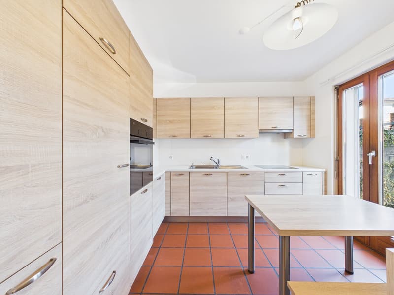wooden kitchen cabinets, countertop, sink, oven, red floor tiles, glass table