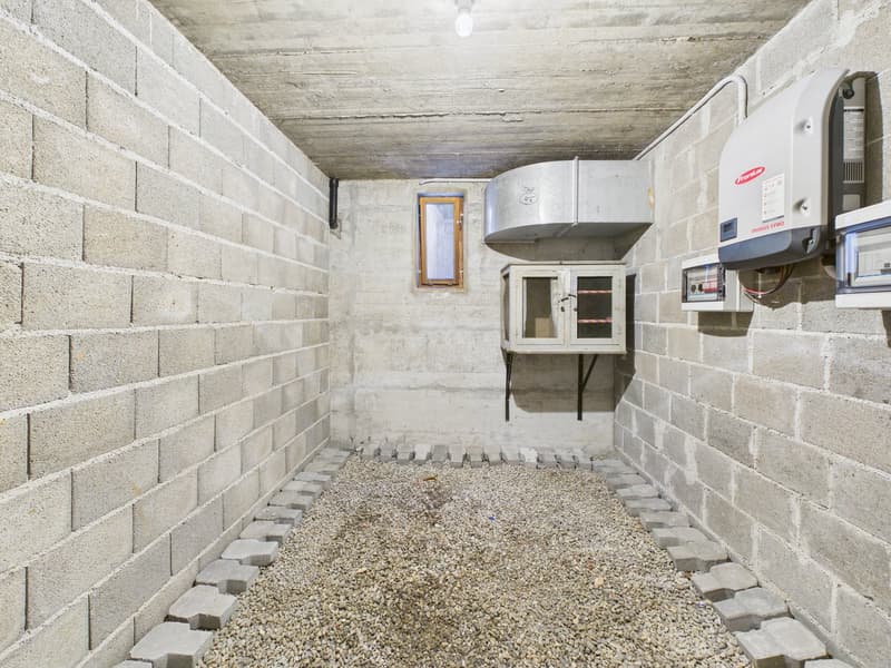 brick walls, grey gravel floor, window, electrical devices, mounted shelf