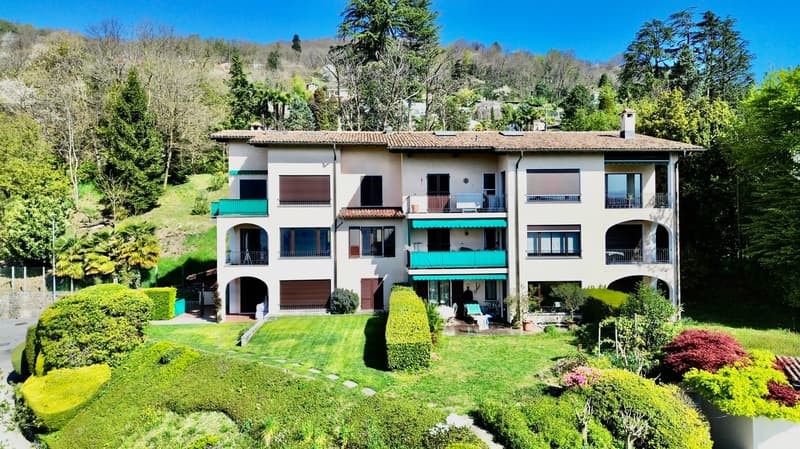 3 story house, white exterior, green balconies, large garden, multiple windows, driveway
