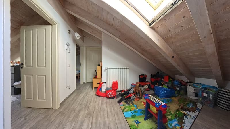 attic room with wooden beams, toys, radiator, skylight, wooden floor