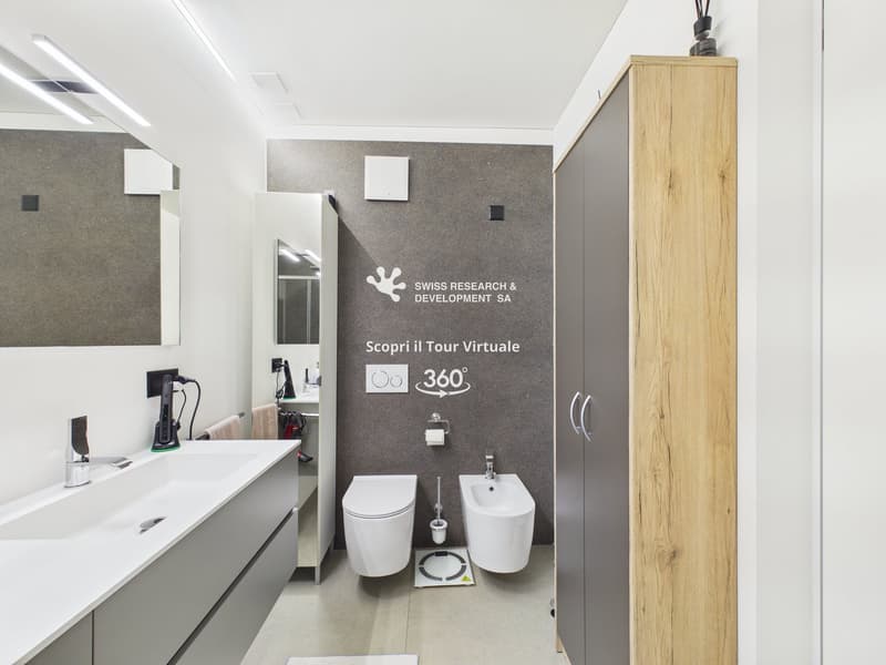 modern bathroom with white sink, white toilet, bidet, wooden cabinet, mirror, power outlet, towel rack