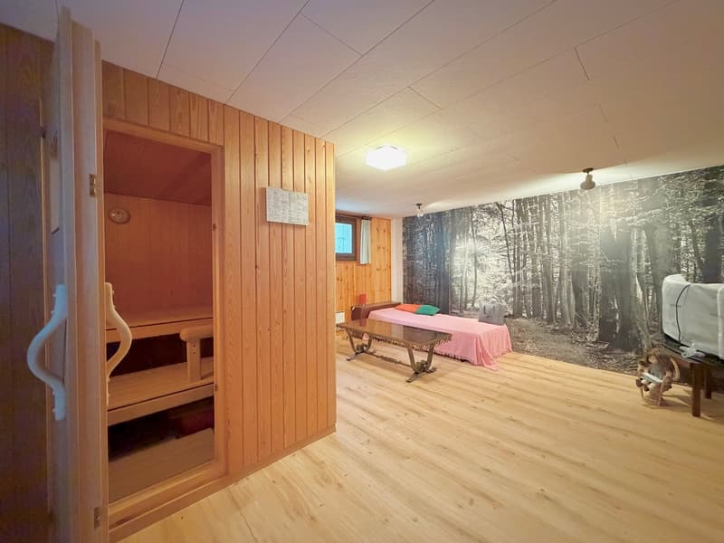 wooden walls, wooden flooring, bedroom area with bed and table, sauna entrance
