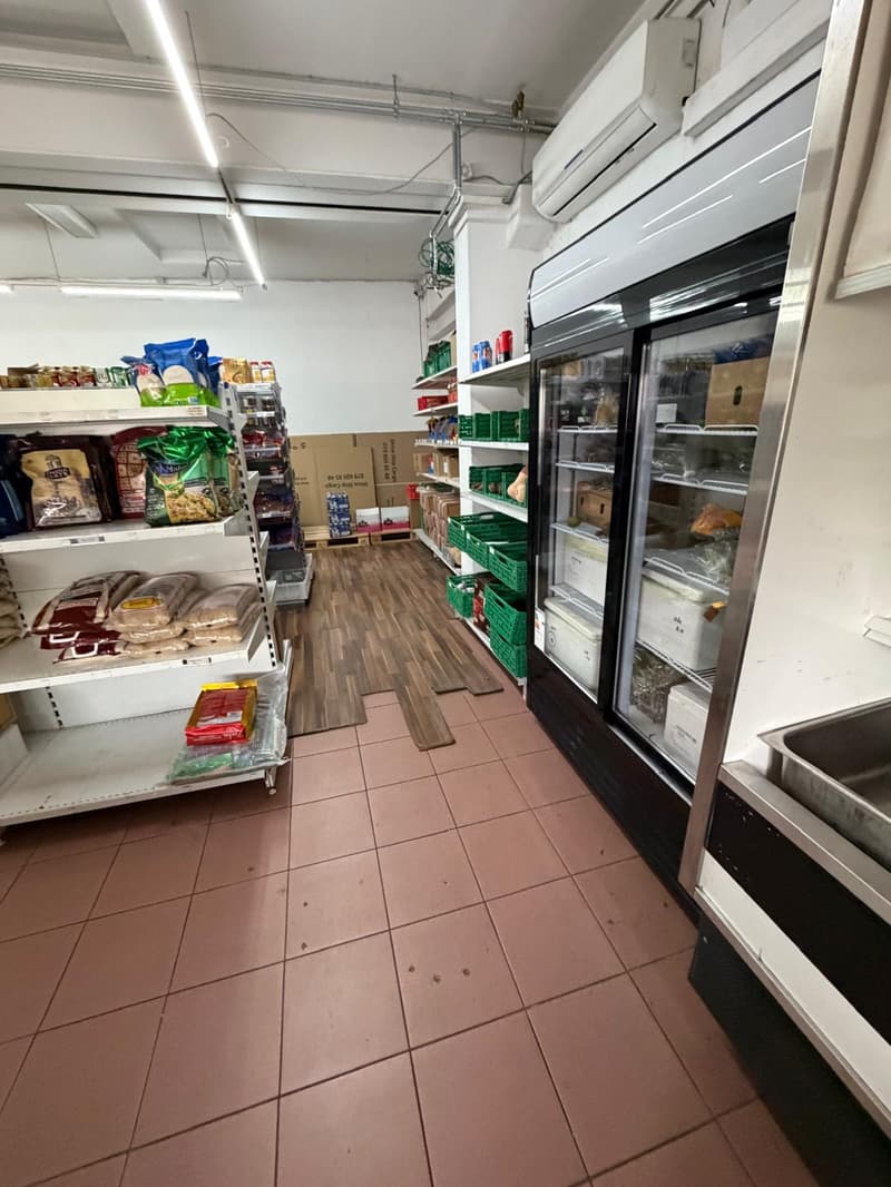 empty store with shelves, refrigerator, and boxes
