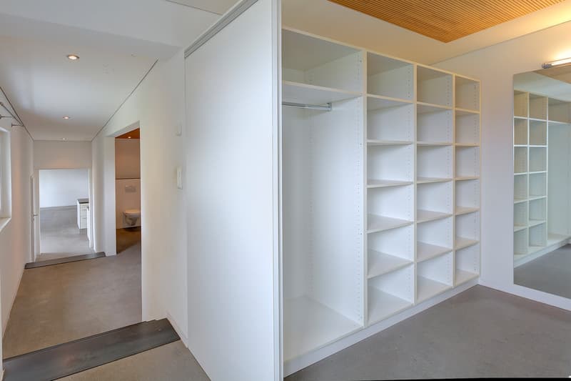 large white wardrobe, white walls, modern toilet, white shelves, white ceiling, bright lights