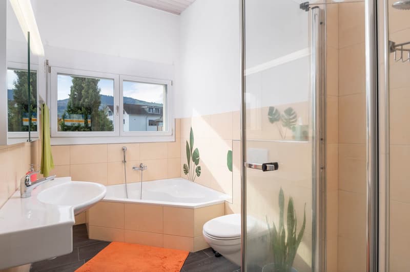 Bathtub, shower, toilet, sink, mirror, towel rack, window with natural light