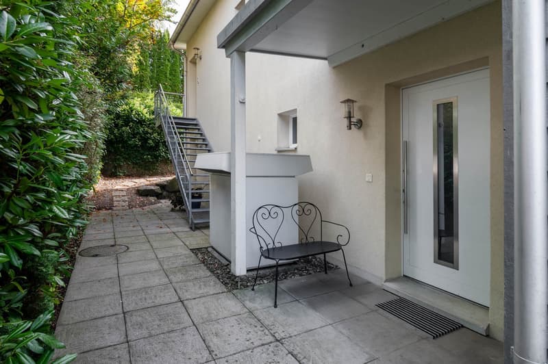 Raised ground floor house, bench, lamp, stairs, garden, white door, tiled floor
