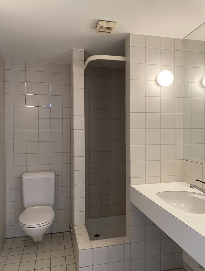 Tiled bathroom with toilet, shower stall, and vanity with sink